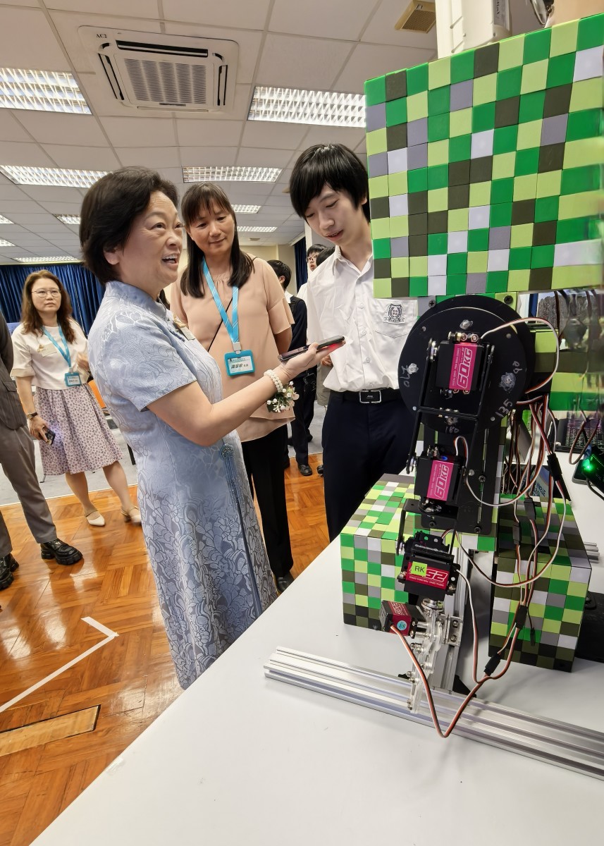 11 高佩璇會長（左）細聽同學講解他們發明的機器人，並與機器人互動