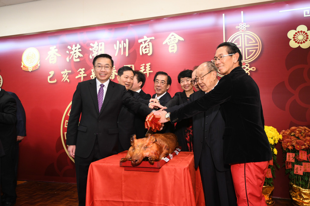 17 中聯辦副主任何靖（左）等各界嘉賓同本會首長切燒豬賀新年