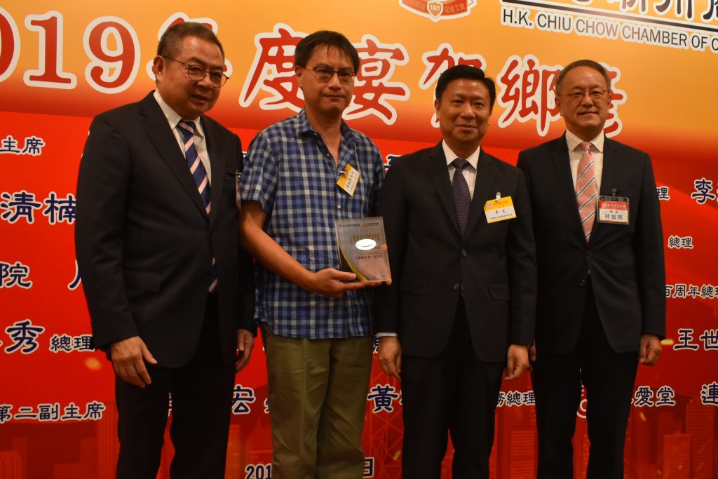 本會會長林宣亮（右一）、香港潮屬社會總會主席陳幼南（左一）與中聯辦社團聯絡部部長李文（右二）致贈賀狀予仁濟醫院第一副主席周松東（左二）s