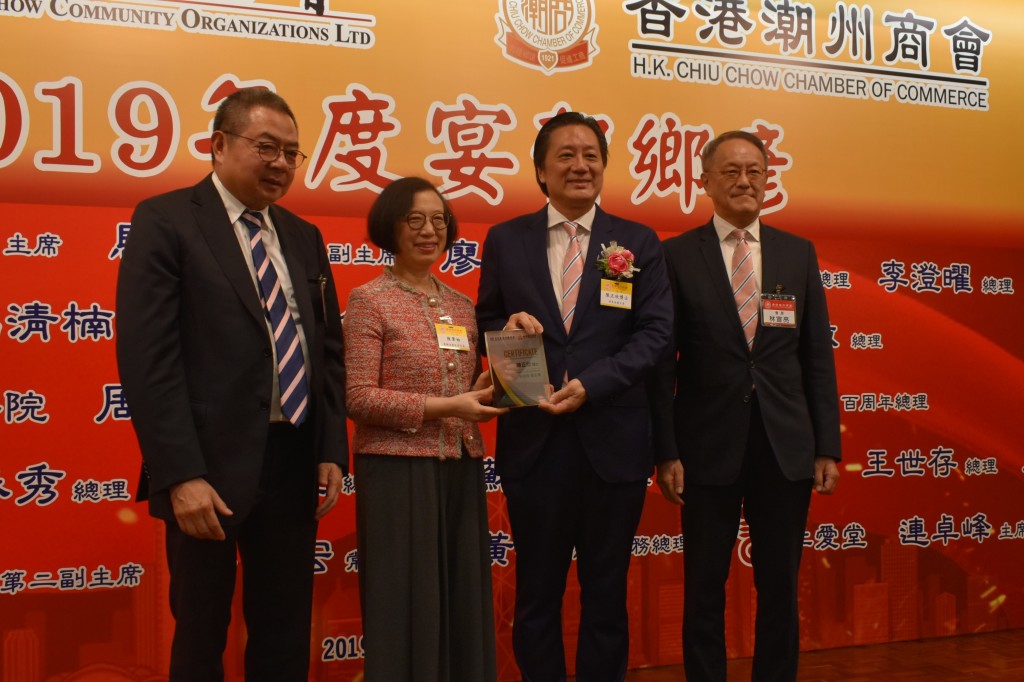 本會會長林宣亮（右一）、香港潮屬社會總會主席陳幼南（左一）與食物及衛生局局長陳肇始（左二）致贈賀狀予會董兼保良局副主席陳正欣（右二）s