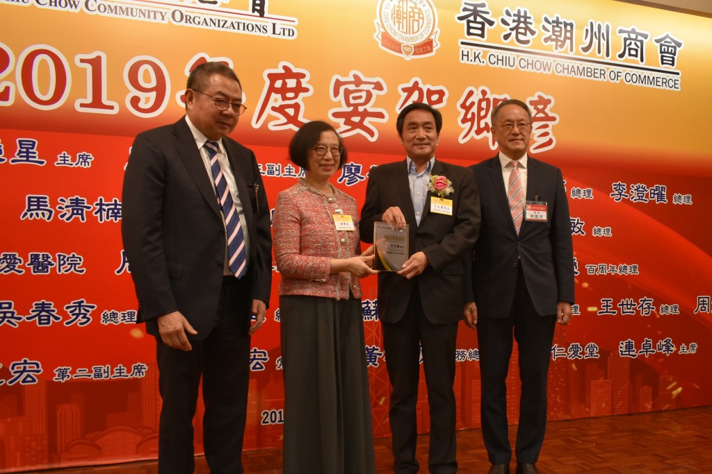 本會會長林宣亮（右一）、香港潮屬社會總會主席陳幼南（左一）與食物及衛生局局長陳肇始（左二）致贈賀狀予會董兼博愛醫院百周年總理王文漢（右二）s