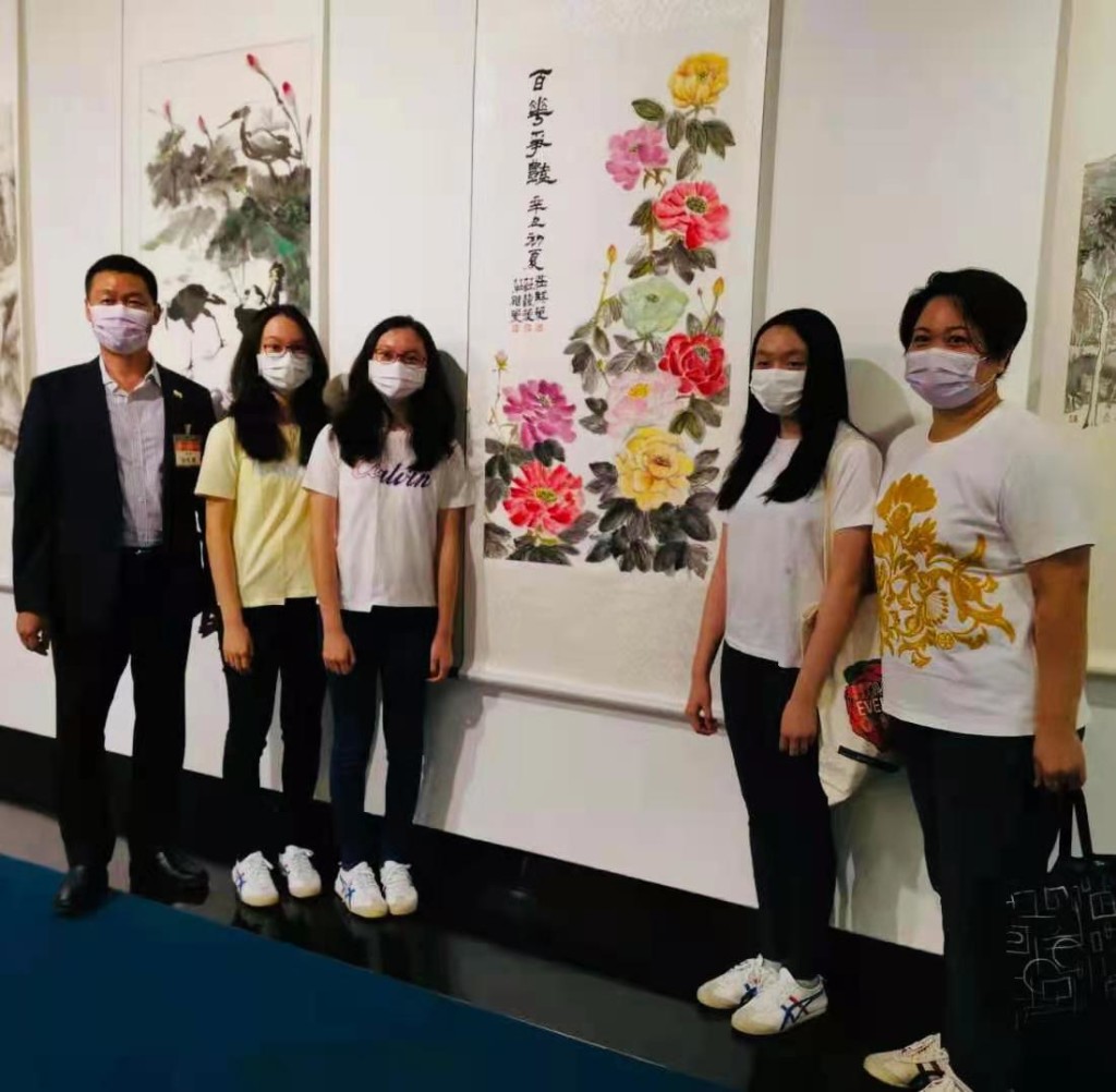 莊永健會董（左一）三胞胎女兒（中三學生）合力創作《百花爭艷》，右為莊永健太太。