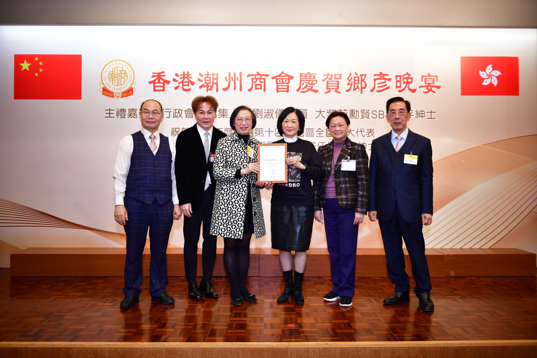 行會召集人葉劉淑儀議員（右三）聯同本會馬鴻銘會長（左二）、高佩璇副會長（右二）、蔡少偉副會長（右一、陳強副會長（左一）致送恭賀狀予獲頒金紫荊星章的陳肇始教授（左三）。