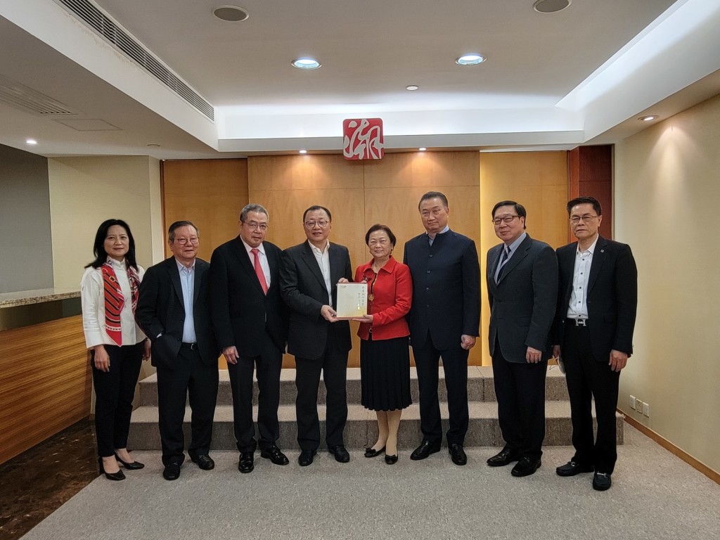 香港潮州商會副會長高佩璇（右四）向汕頭市委常委蔡永明（左四）致送香港潮州商會百年發展史。