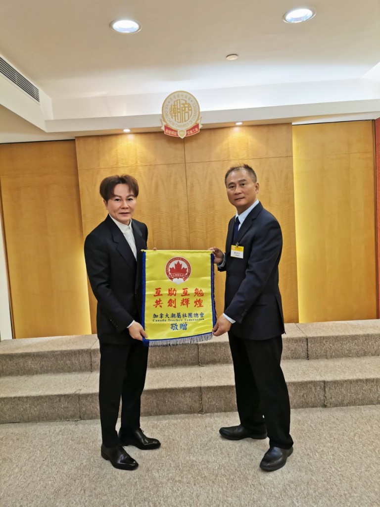 加拿大潮屬社團總會陳育昭會（右）長致送錦旗予馬鴻銘會長